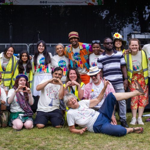 Bristol Refugee Festival participants posing together in colourful festival T-shirts.