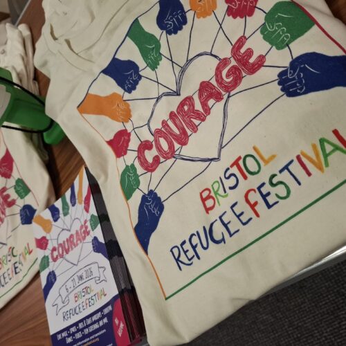 Close-up of the colourful Courage design on a Bristol Refugee Festival 2026 T-shirt.
